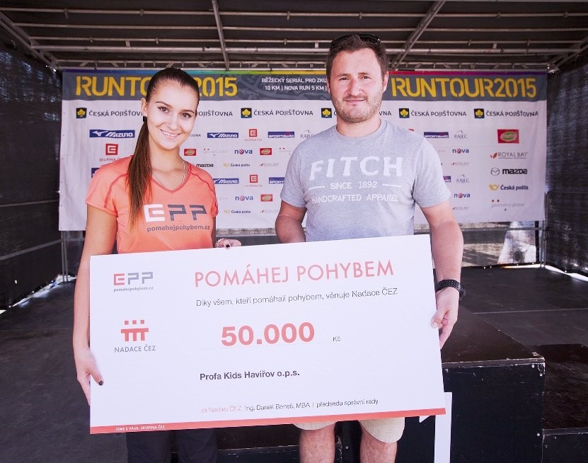 Zástupce pořadatelů RunTour Martin Pešta přebírá od hostesky šek pro neziskovku Profa Kids.