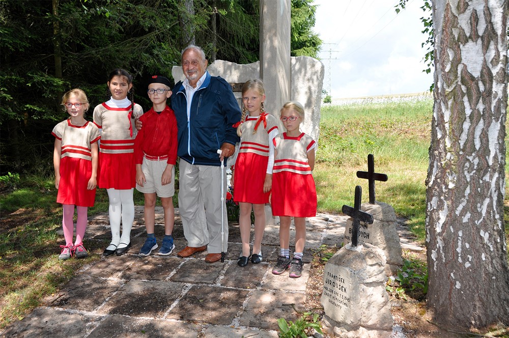 Antonín Burdych, syn popravených manželů Burdychových, se sokolskými dětmi u pomníku na Končinách v místě, kde byl 30. června 1942 zastřelen německými okupanty jeho otec.